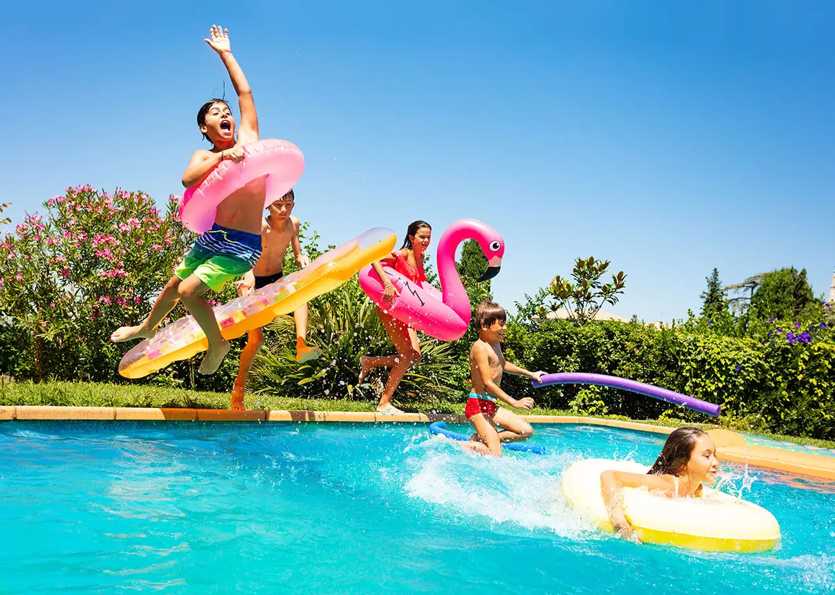 Happy friends jumping in pool on the vacations Happy friends jumping in pool on the vacations